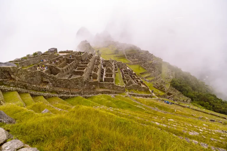 ruinas incas de Machu Picchu al amanecer con montañas verdes de fondo